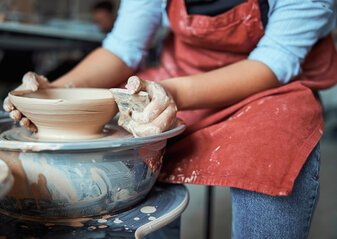Female ceramist polishing clay bowl in workshop
