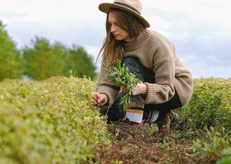 Zdjęcie przedstawia kobietę pracującą na polu.